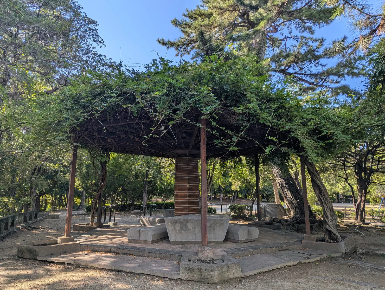緑ヶ丘公園の木々に囲まれたあずまやとベンチ